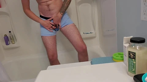 Joven chico trans boxeador meando en la ducha